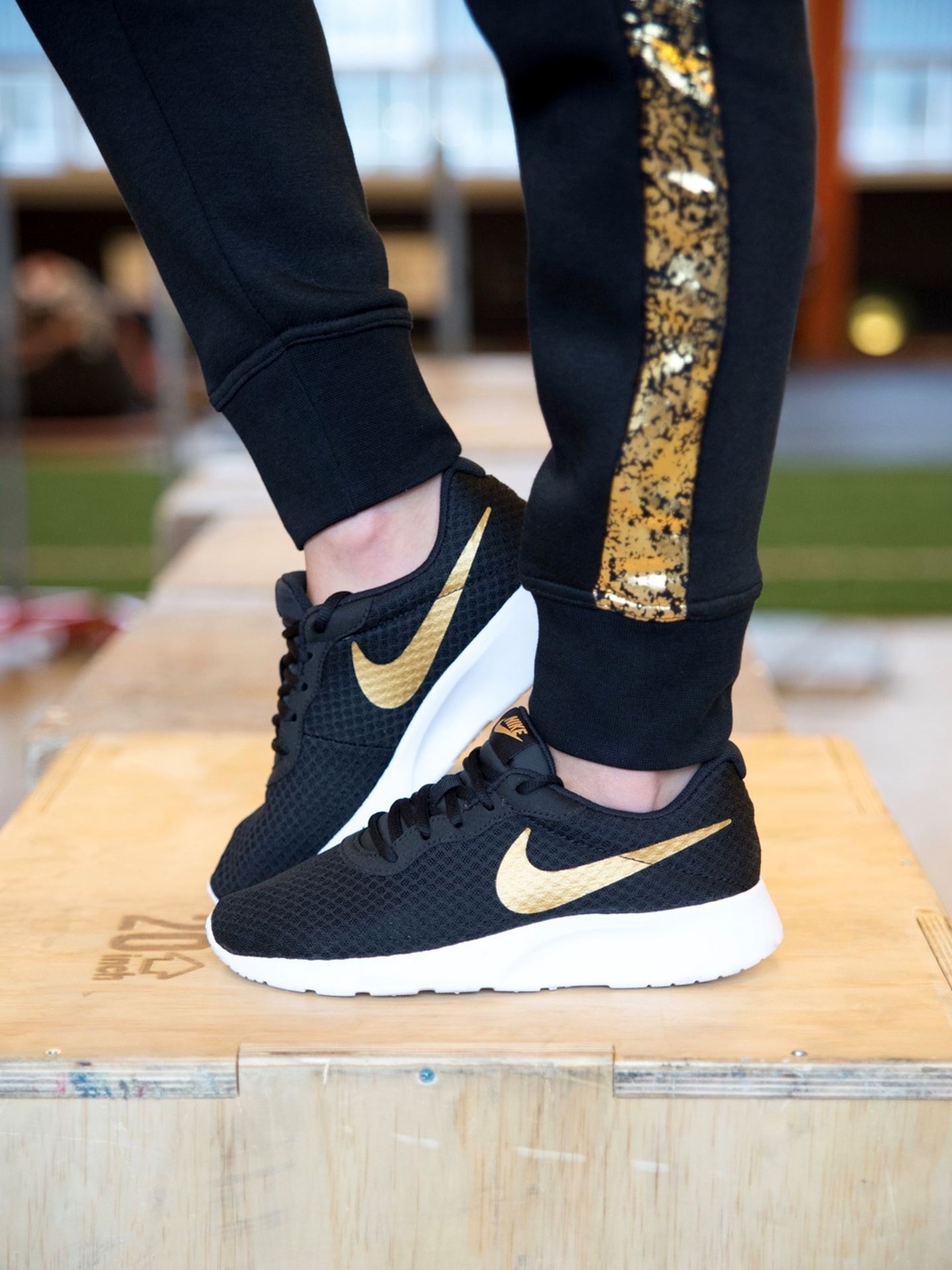 Nike tanjun sale black metallic gold